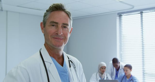 Confident Senior Male Doctor Leading Diverse Medical Team in Modern Hospital - Download Free Stock Images Pikwizard.com