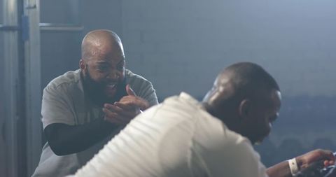 Intense gym coaching: African trainer motivating athlete in high-intensity bench workout
