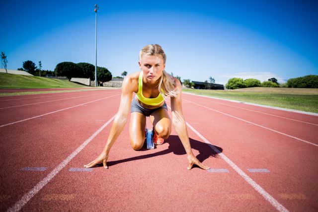 Female athlete ready to run on running track on a sunny day