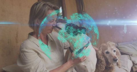 Woman cuddling two dogs with holographic globe display