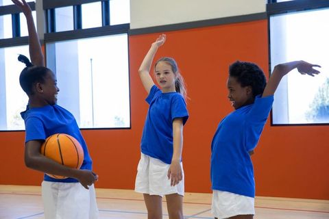 Dynamic Youth Basketball Teammates in Gym Celebrating Success