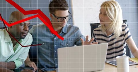 Analyzing declining sales data on laptop with team and red downtrend overlay