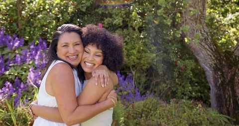 Happy Mother and Daughter Hugging in Sunlit Garden