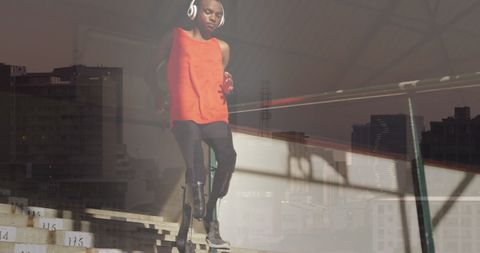 Double exposure of athlete with artificial legs and cityscape