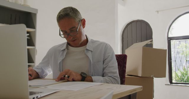 Middle-aged man working on paperwork at home office - Download Free Stock Images Pikwizard.com