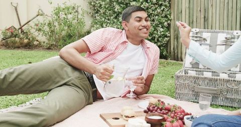 Young Couple Laughing During Relaxed Picnic Barbecue Feast