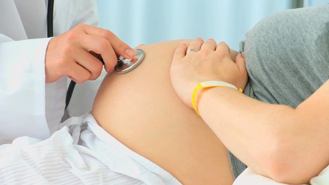 This scene captures a medical professional performing a prenatal examination on a pregnant woman, emphasizing prenatal healthcare and monitoring. Useful for content related to pregnancy care, maternal health, medical consultations, or healthcare education materials.