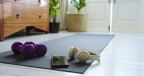 Home workout space with yoga mat, dumbbells and headphones