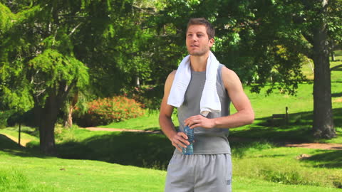 Man Refreshing After Workout in Lush Green Park