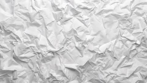 Studio camera sweeping over crumpled white paper revealing deep folds and texture