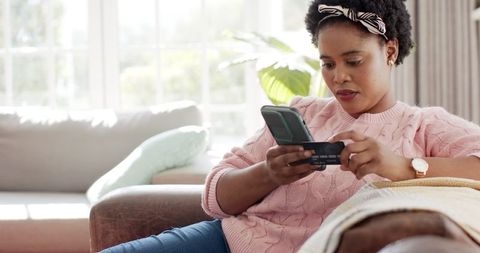 Woman Shopping Online Using Credit Card at Home