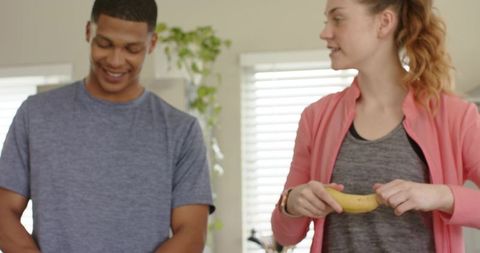 Diverse young couple smiling in bright kitchen preparing healthy breakfast
