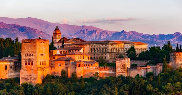 Captures the majestic Alhambra palace in Granada, Spain, bathed in the warm hues of sunset. The striking Sierra Nevada mountain range provides a breathtaking backdrop. Ideal for travel brochures, cultural study materials, tourism advertisements, and educational content about Spain’s heritage and historical landmarks.