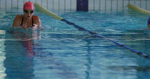 Athlete practicing breaststroke in indoor swimming pool