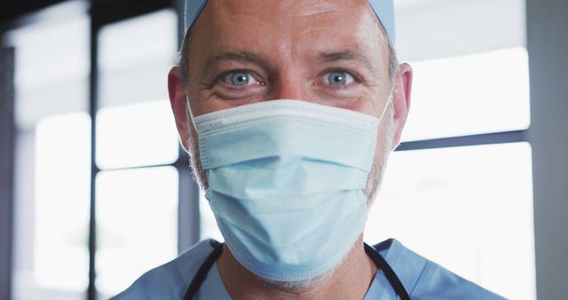 Happy Medical Professional in Facial Mask and Scrubs in Hospital Environment - Download Free Stock Images Pikwizard.com