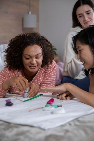 Diverse friends enjoy nail art at home relaxation