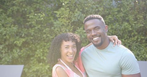 Smiling African American Couple Embracing in Sunlit Garden