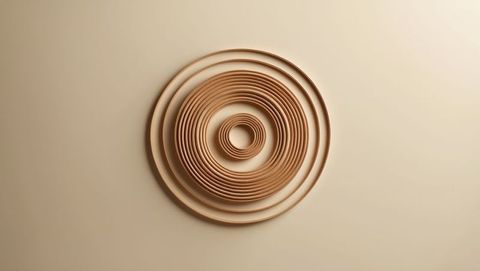 Geometric concentric sandalwood ring sculpture on beige wall