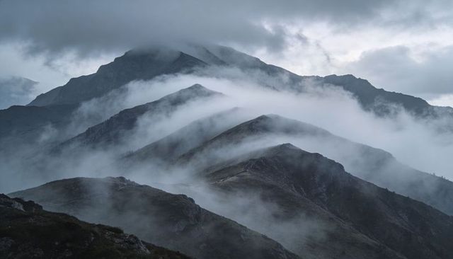 Misty Alpine Ridge Layers with Ribbon Fog Rolling Across Remote Rocky Peaks and Valleys