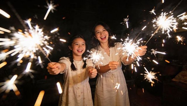 Mother and daughter celebrating with sparklers nighttime joy warm home glow