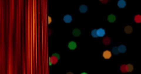 Red curtain unfurls against a backdrop of flickering, colorful Christmas lights, creating a festive and warm holiday atmosphere. Perfect for seasonal greeting cards and holiday-themed event promotions.