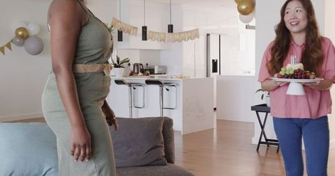 Lesbian couple preparing for birthday celebration at home