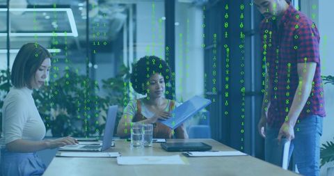 Multicultural team collaborating over analytics and streaming code in modern boardroom