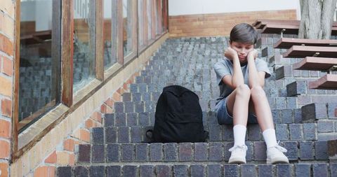 Boy Sitting Alone on Brick Steps Feeling Contemplative