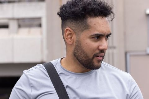 Urban athlete glancing right wearing gray performance shirt and crossbody strap