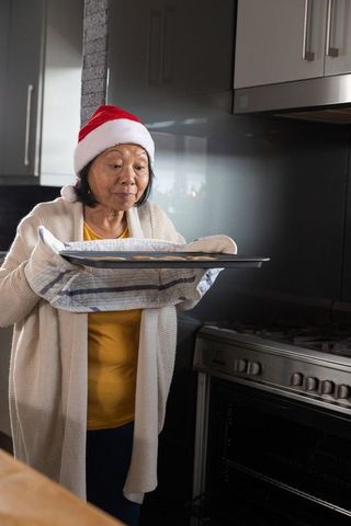 Senior Woman Baking Cookies at Christmas in Modern Kitchen