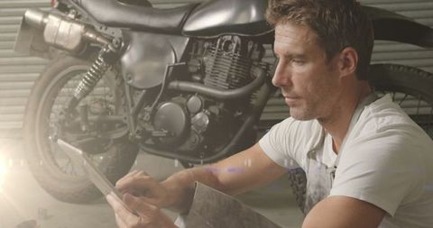 Focused Mechanic Restoring Motorbike in Garage