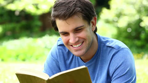 Smiling Man Enjoying a Good Book Outdoors in Nature