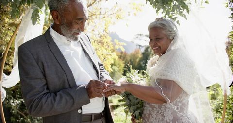 Elderly couple celebrating wedding ceremony outdoors