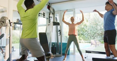Group Fitness Training with Multiracial Friends in Bright Gym