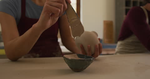 Female Potter Applying Glaze in Artisan Studio