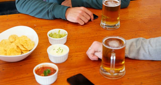 Casual Social Gathering at Wooden Table with Snacks and Drinks - Download Free Stock Images Pikwizard.com