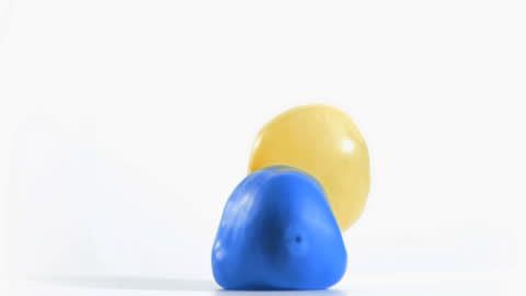 Yellow Balloon Bouncing on Blue Balloon in Slow Motion