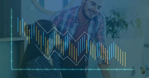 Colleagues Analyzing Data on Monitor with Chart Overlay in Office Environment