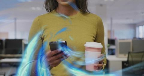 Professional checking smartphone holding coffee in modern open-plan office with neon glow