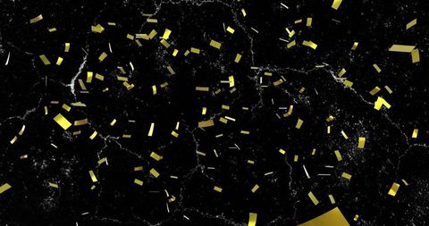Floating gold confetti over black marble, shimmering metallic foil fragments and glitter