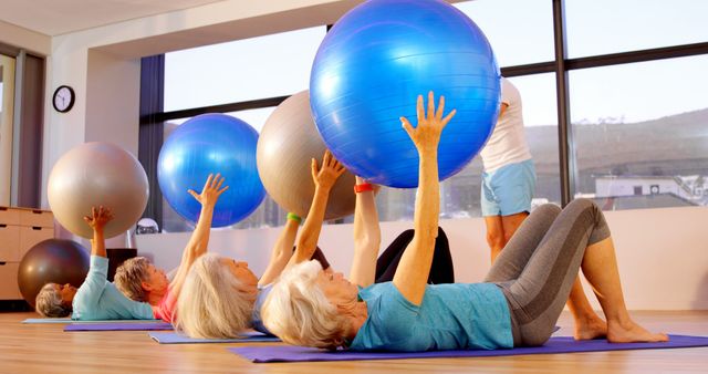 Elderly people use exercise balls in a fitness class to stay healthy and active. - Download Free Stock Photos Pikwizard.com