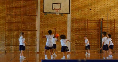 Youth basketball practice in school gymnasium kids playing team sport
