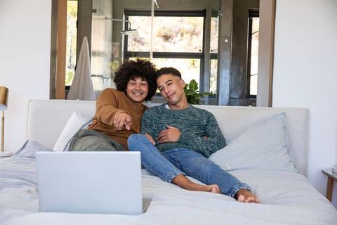 Loving Couple Relaxed with Laptop in Cozy Modern Bedroom