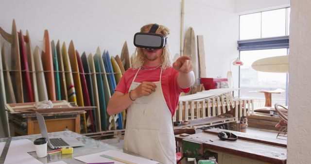 Young Man Using VR Headset in Surfboard Workshop - Download Free Stock Images Pikwizard.com