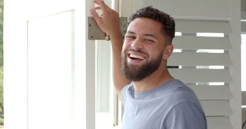 Man Enjoying Bright Day by Window with Plantation Shutters