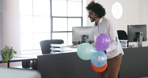 Cheerful Businessman Bringing Balloons to Office Celebration