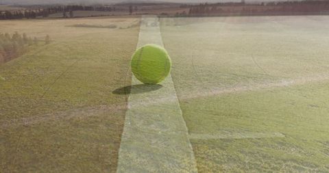 Vibrant tennis court with rural landscape and crop fields