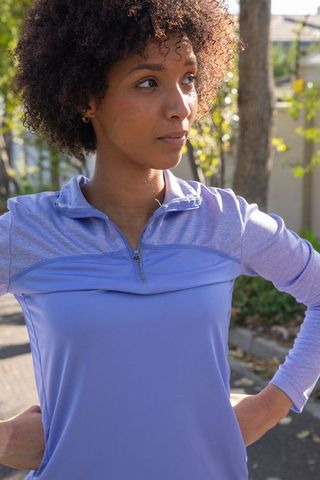 Confident Woman in Lavender Activewear on Sunlit Street