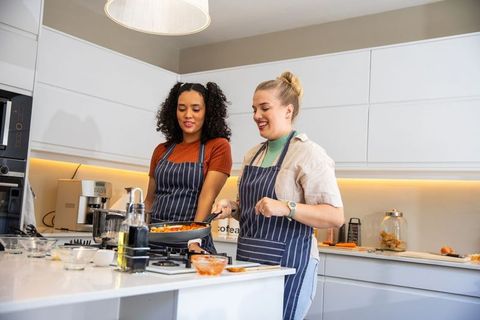 Diverse Female Friends Collaboratively Cooking in Modern Kitchen