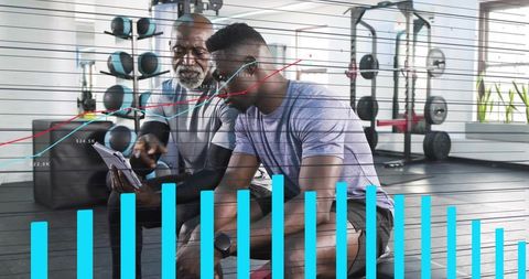 Fitness coach analyzing performance metrics with client on tablet in gym using charts